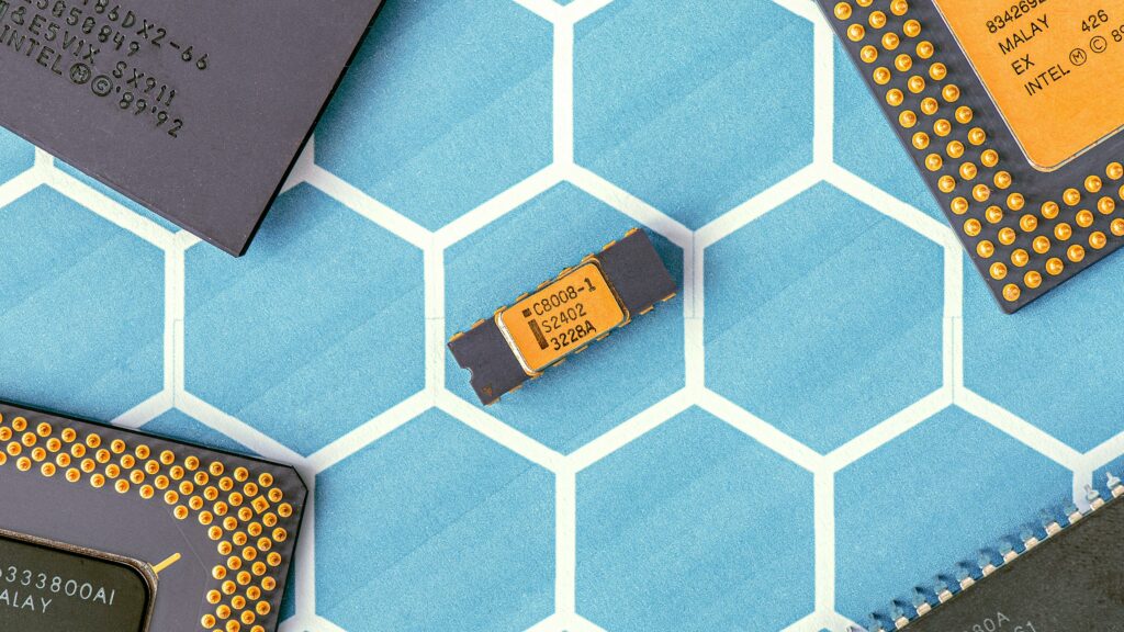 Close-up of various microprocessor chips on a blue hexagonal patterned surface, highlighting electronic technology.
